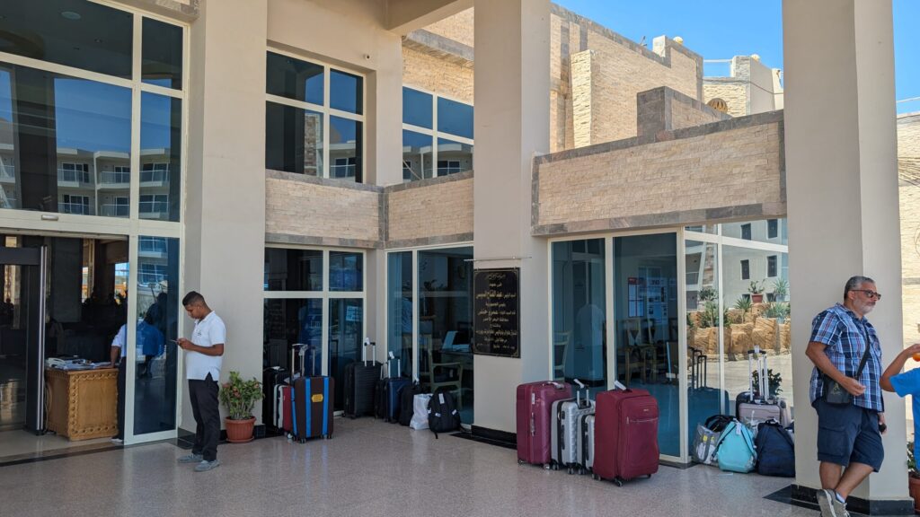 Hoteleingang in Hurghada mit Gepäck und ankommenden Gästen.